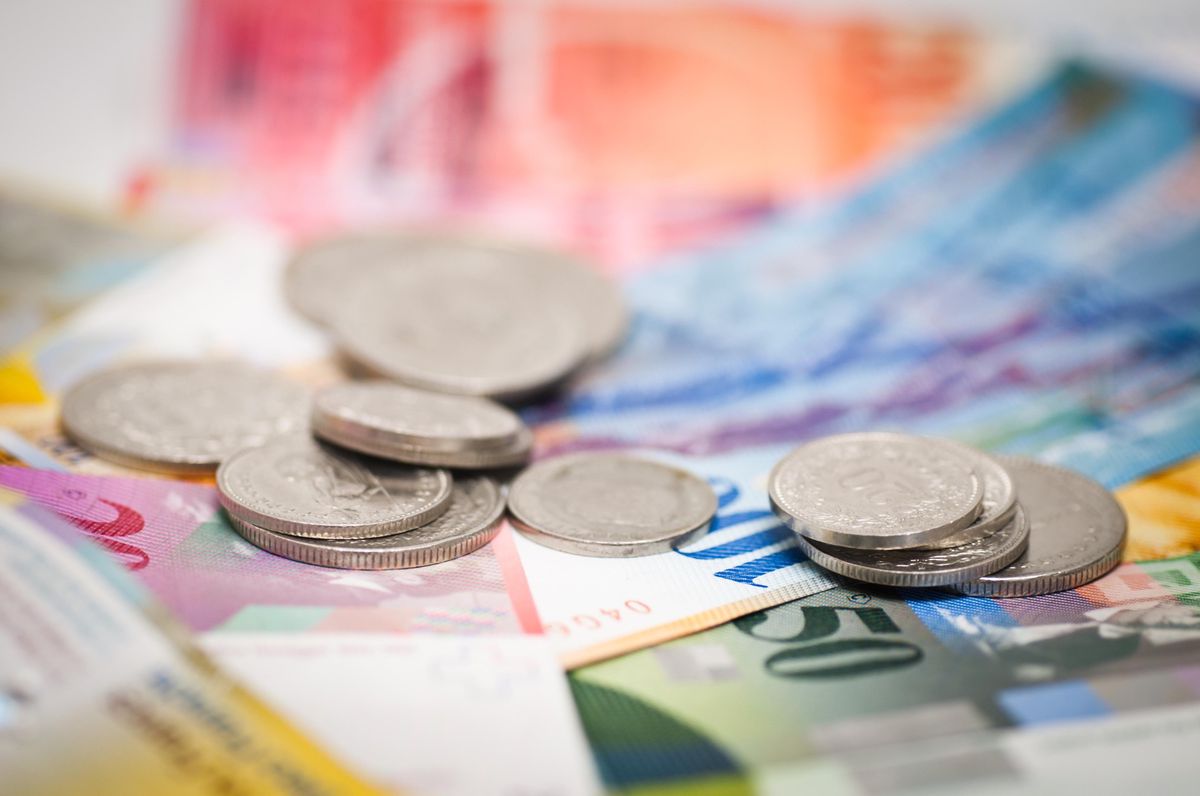 Billets et pièces suisses sur une table.