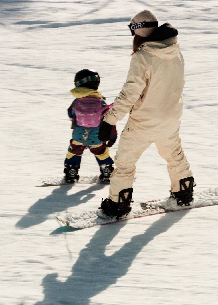 L'auteure et son fils de quatre ans sur des snowboards dans la neige.