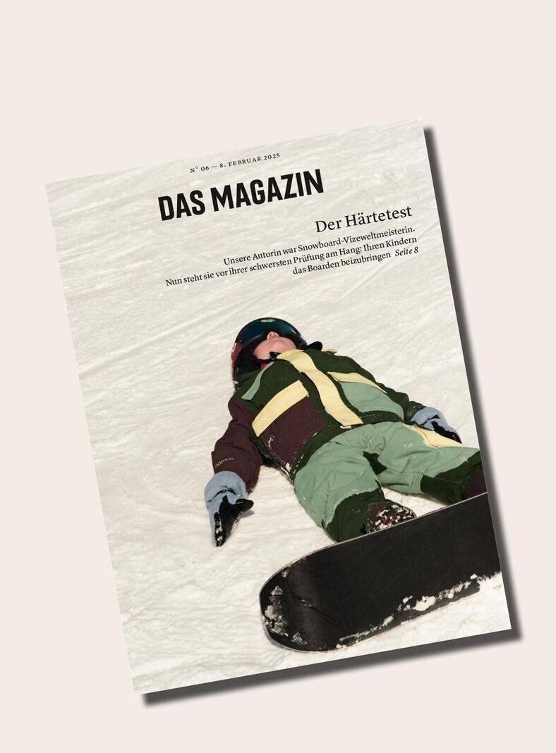 Le plus jeune fils de l'auteur en tenue d'hiver avec un snowboard, regardant le ciel.