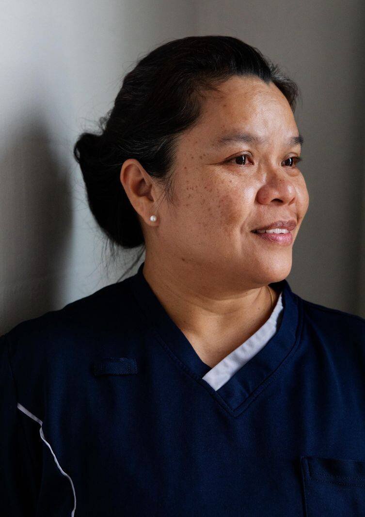 Porträt der Ligthouse-Mitarbeiterin Gung. Sie trägt eine dunkle Uniform und blickt lächelnd zur Seite.