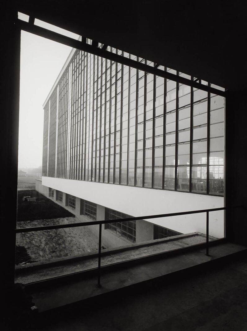 Photographie en noir et blanc d'un bâtiment moderne avec de grandes baies vitrées.