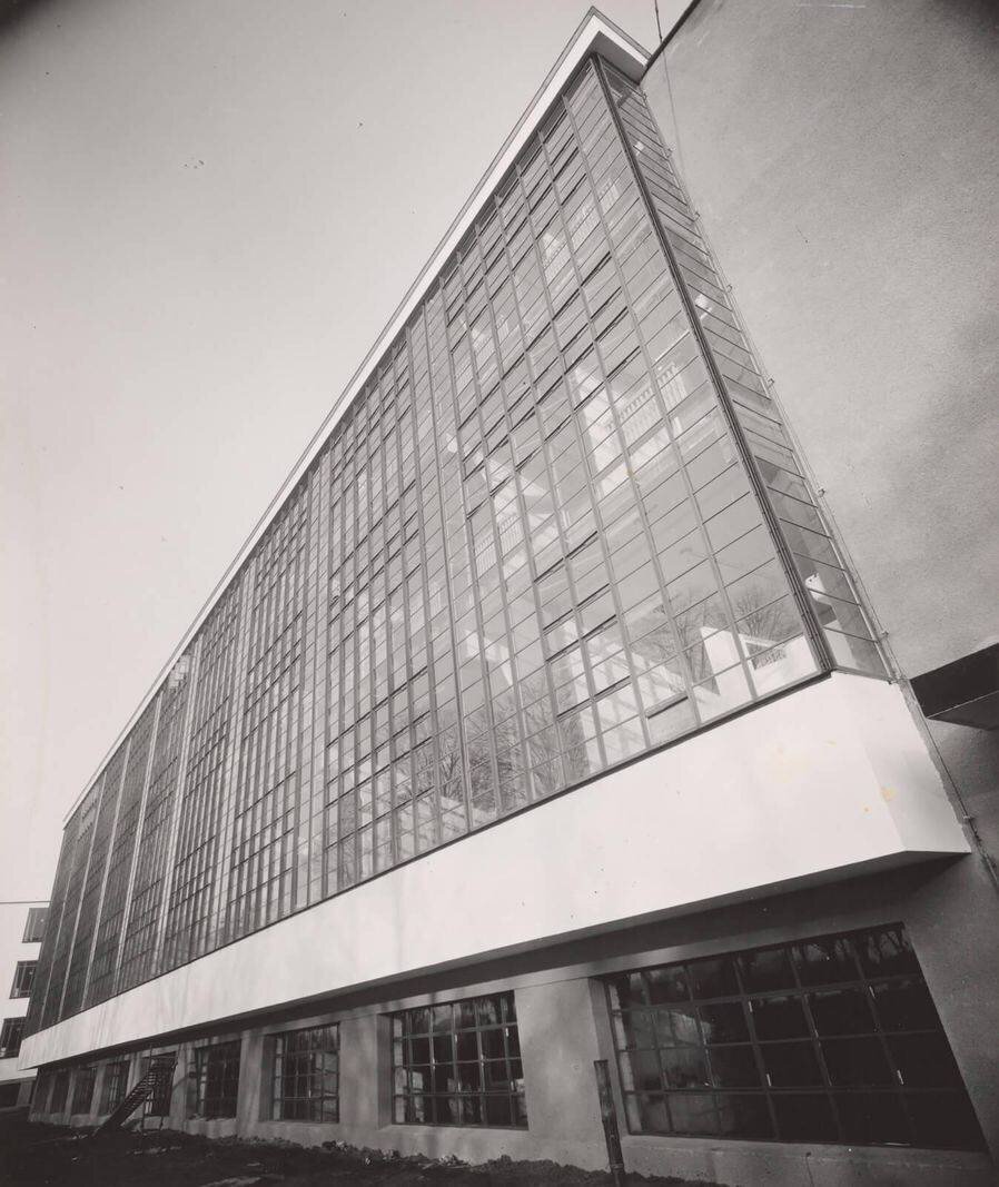 Photo en noir et blanc d'un bâtiment moderne avec une grande façade en verre.