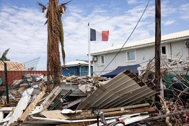 Le drapeau flotte au-dessus de bâtiments ravagés par un cyclone dans la commune de Dzaoudzi, à Mayotte, le 28 décembre 2024.