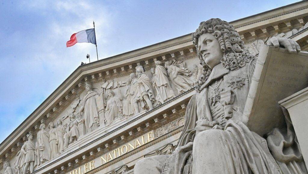 La façade de l'Assemblée nationale à Paris, surmontée d'un drapeau de la France