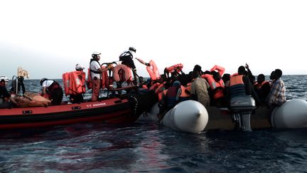 Des membres de l'association SOS Méditerranée viennent en aide à des migrants dans la zone de recherche et de secours de la mer du même nom, le 9 juin 2018. (KARPOV / SOS MEDITERRANEE)