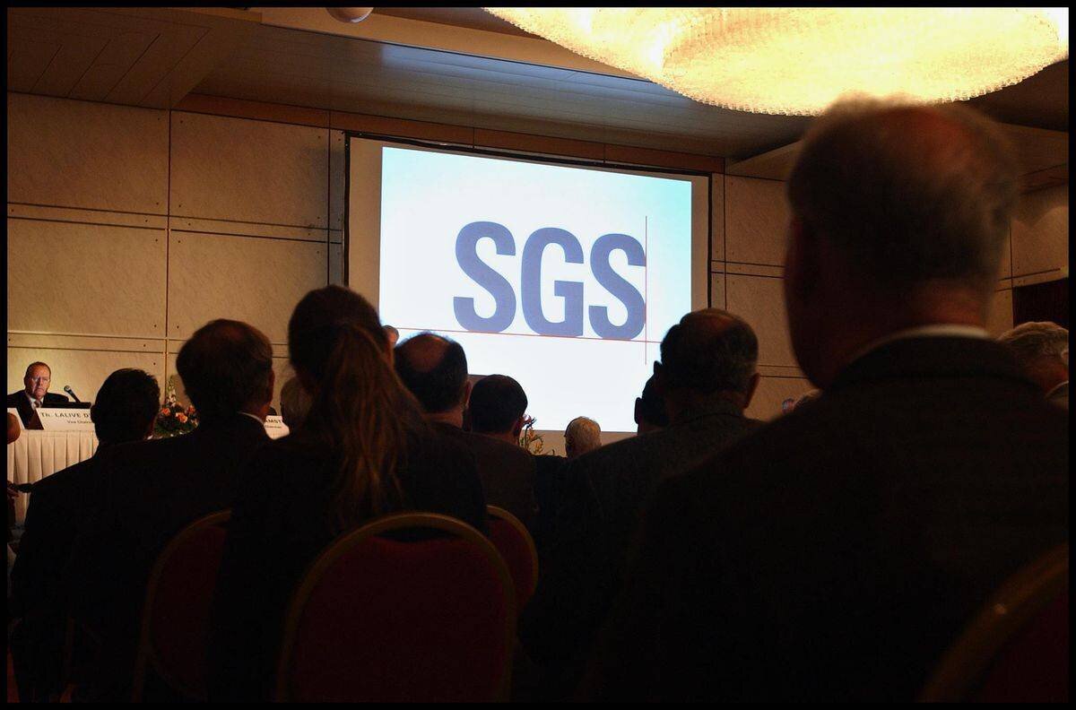 Conférence de la multinationale genevoise SGS avec des participants assis, le logo SGS affiché à l’écran principal.