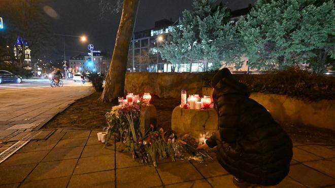 Femme déposant des fleurs en mémoire des victimes