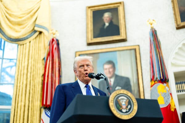 Donald Trump speaks into a microphone at a lectern inside the Oval Office at the White House.