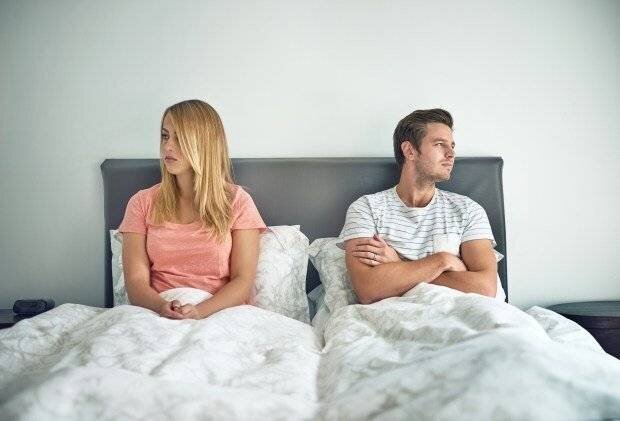 Un jeune couple s'ignorant dans le lit.