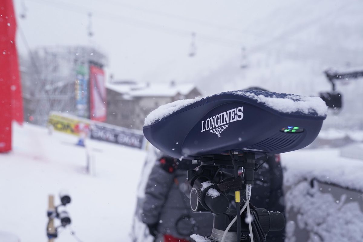 Gros plan d'un appareil de chronométrage Longines dans une station de ski enneigée.
