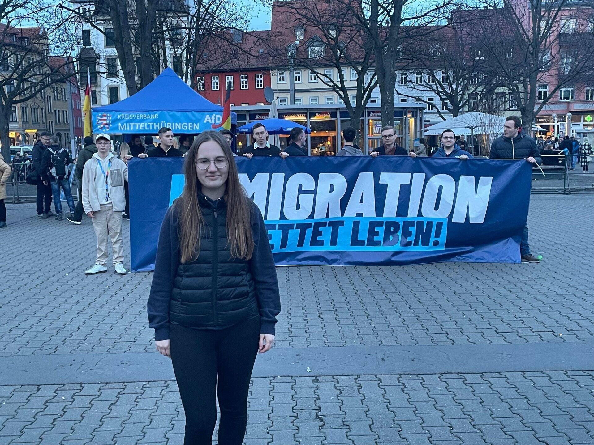 Caroline Lichtenheld, 22 ans, devant une affiche appelant à la remigration