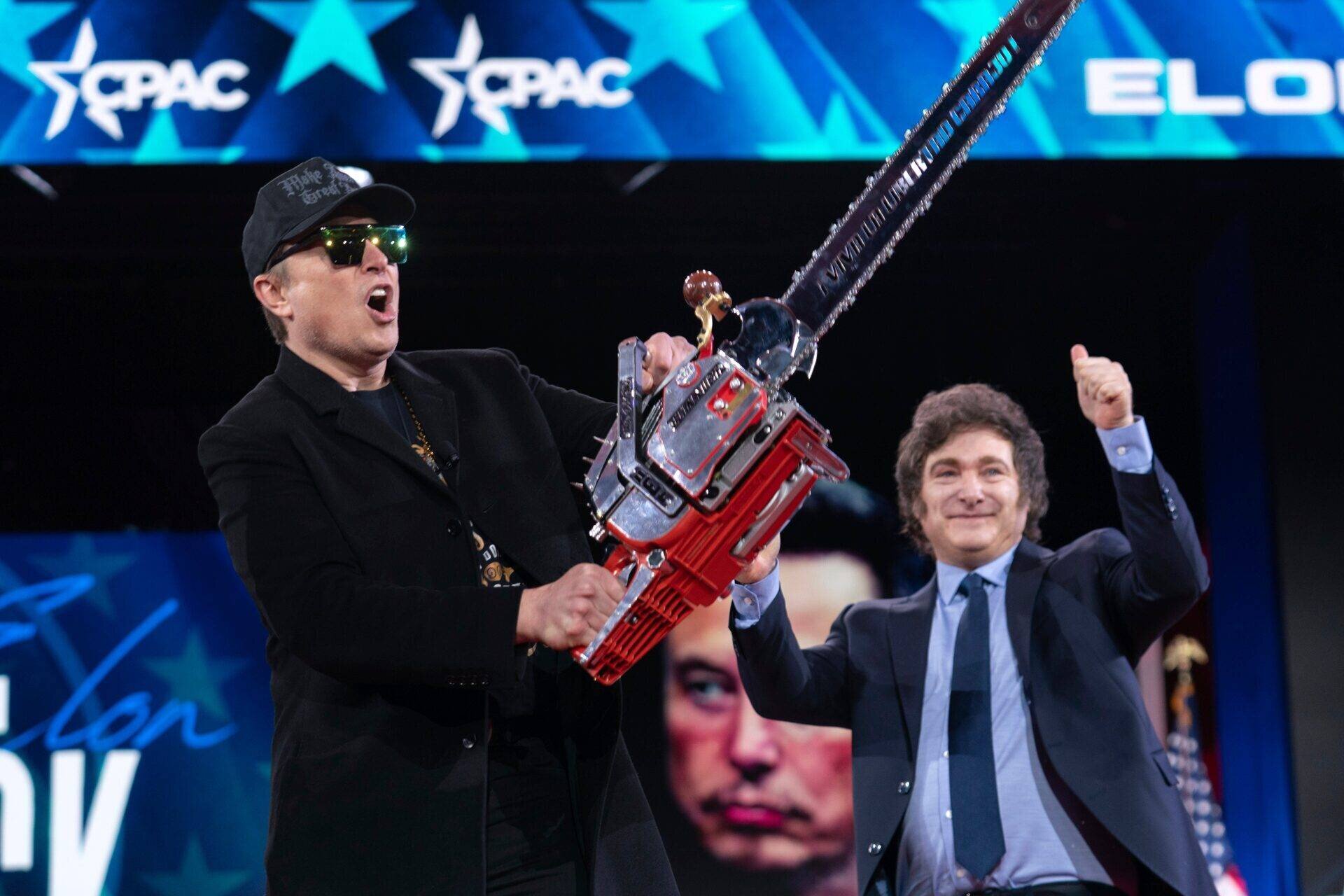 Elon Musk brandissant une tronçonneuse sur scène à CPAC avec le président argentin Javier Milei.