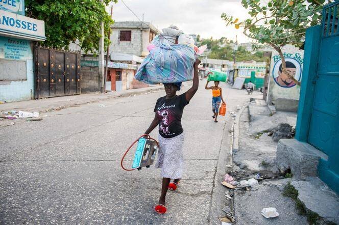 Une femme porte un baluchon sur sa tête alors que les habitants fuient leurs maisons pour échapper à la violence des gangs dans le quartier de Delmas à Port-au-Prince, en Haïti, le 25 février 2025.