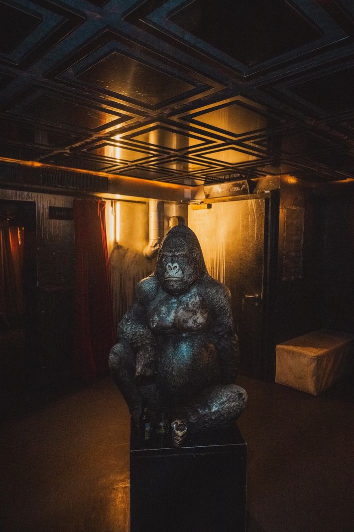 Lounge sombre avec une statue de gorille dans le club 'Das Ende der Zukunft'.
