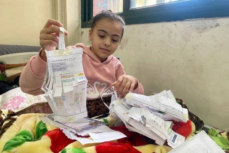 Manah, la petite fille blessée, fabrique un lanternon en papier pour célébrer le mois de Ramadan dans son lit à l'hôpital Nasser.