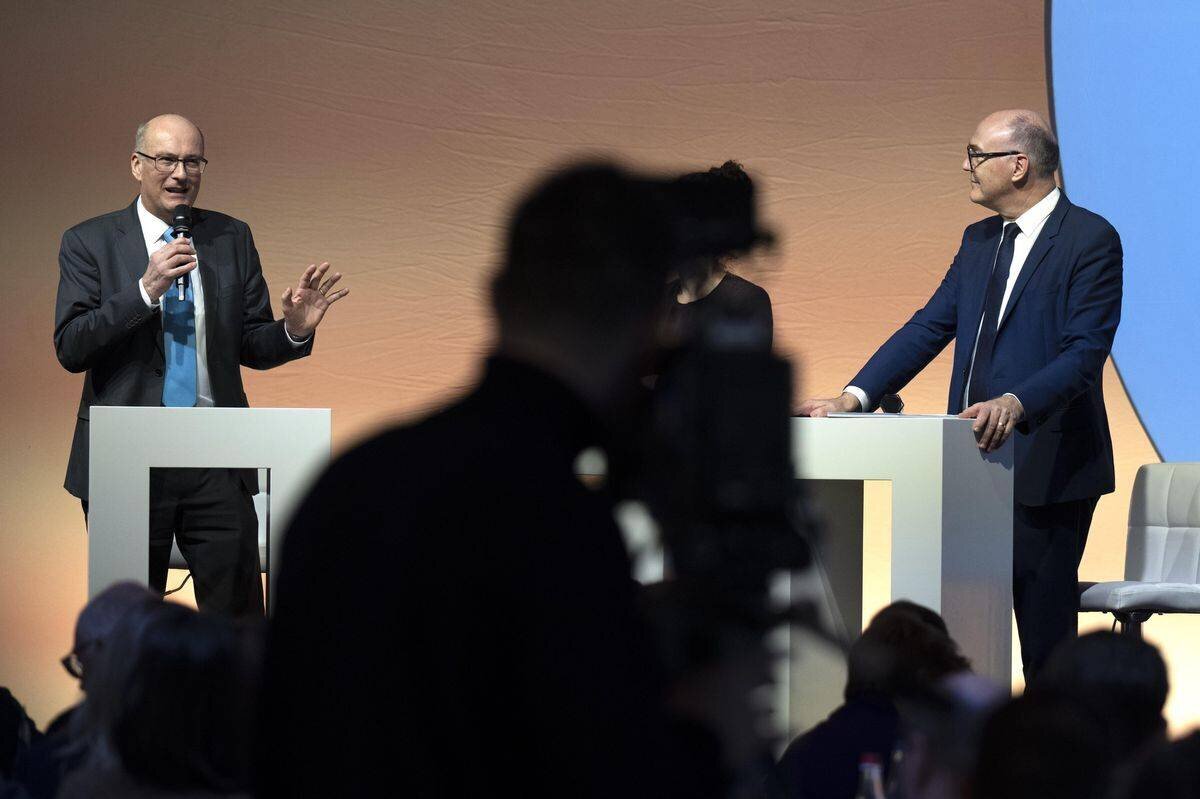 Markus Ritter et Martin Pfister discutent lors d’un podium à l’assemblée des délégués du parti Mitte, à Visp, le 22 février 2025.
