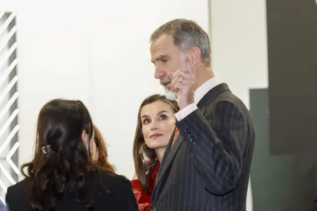 Le roi converse avec une galeriste, devant la reine.