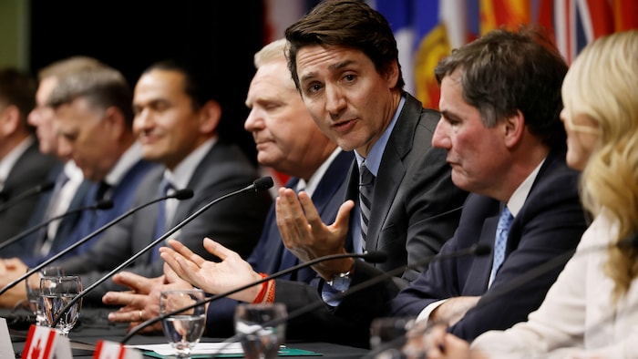 Justin Trudeau parle aux côtes des premiers ministres provinciaux et de certains ministres.