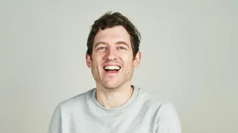 Elis James souriant à la caméra