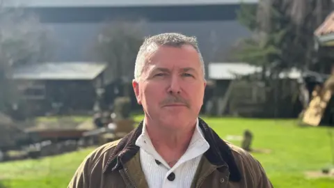 Alan Thomas et l'entrepôt en arrière-plan