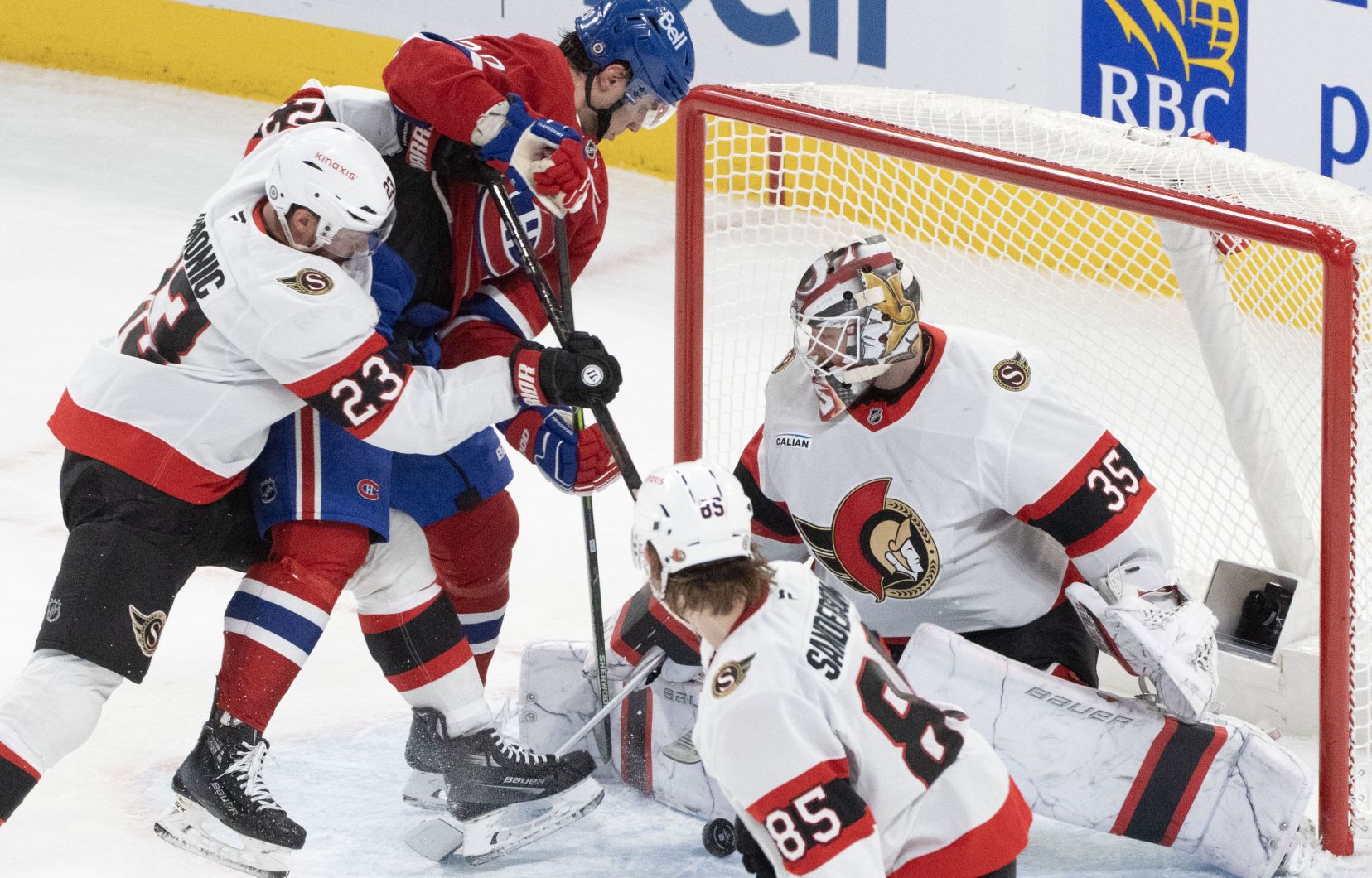 L'attaquant du Canadien de Montréal Juraj Slafkovsky tente de profiter d'une rondelle libre devant le gardien des Sénateurs d'Ottawa Linus Ullmark durant la deuxième période d'un match de hockey de la LNH, le mardi 18 mars 2025.