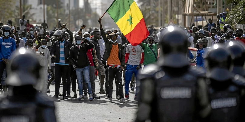 Un manifestant brandit le drapeau national sénégalais lors d’une manifestation de soutien à Ousmane Sonko à Dakar, le 3 mars 2021.65 personnes ont été tuées lors des violences politiques de 2021 à 2024, selon le bilan établi par un collectif citoyen.