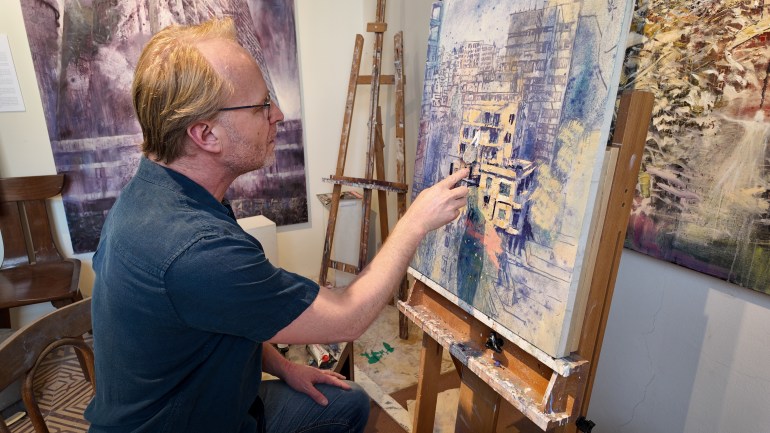 L'artiste britannique Tom Young en train de peindre dans son atelier
