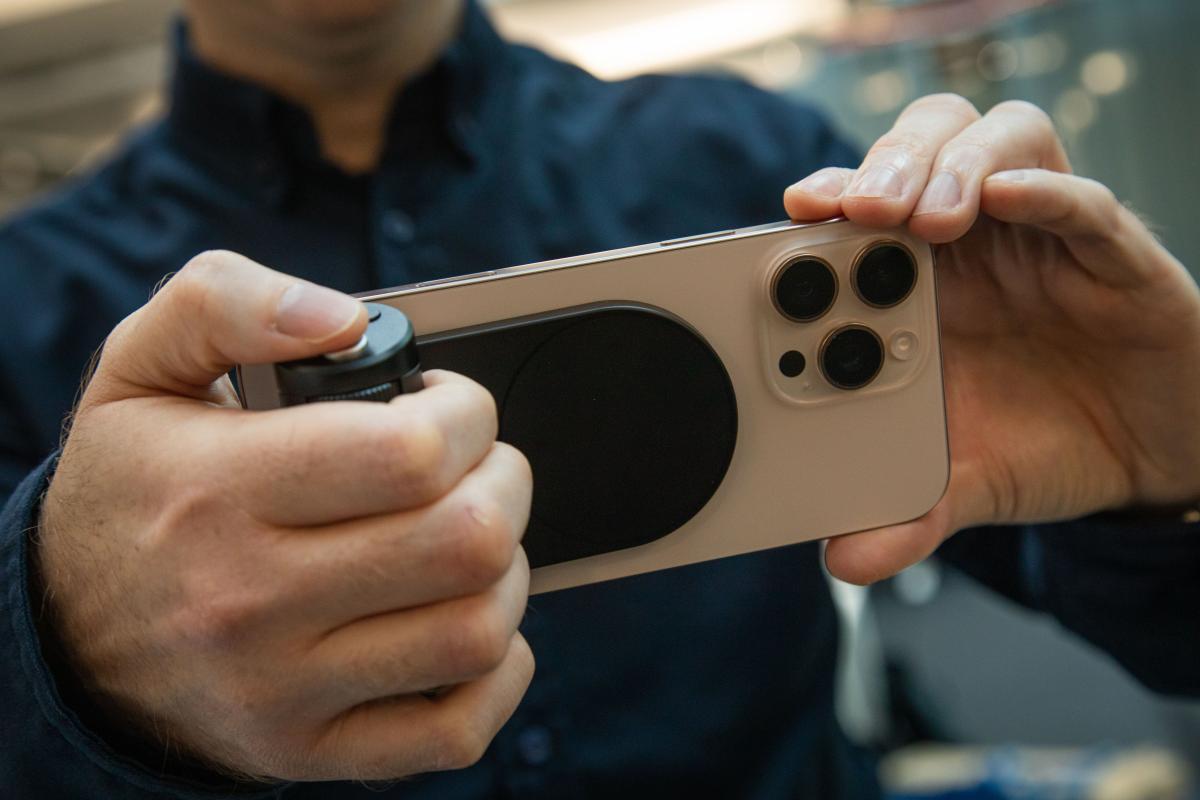Un utilisateur tenant son smartphone avec le Leica Lux Grip.