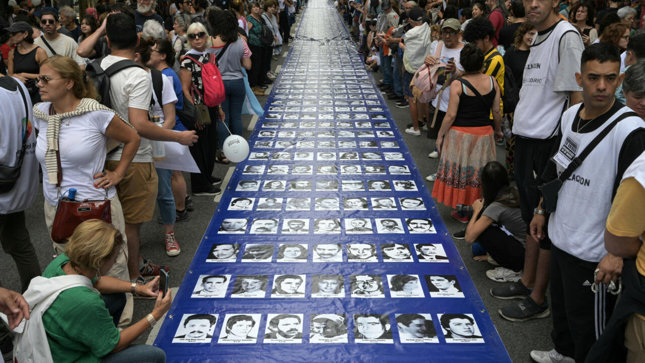 Une bannière avec des portraits de disparus pendant la dictature militaire est transportée vers la Place de Mai pour commémorer le 49e anniversaire du coup d'État, à Buenos Aires, lundi 24 mars 2025.
