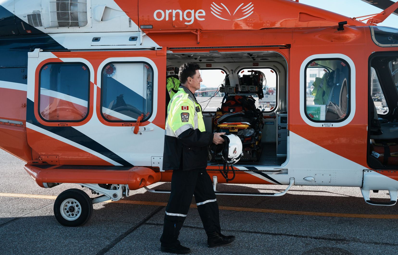 Un pilote s’approche d’un hélicoptère du service d’ambulance aérienne ORNGE à sa base de Toronto, le 13 décembre 2022.