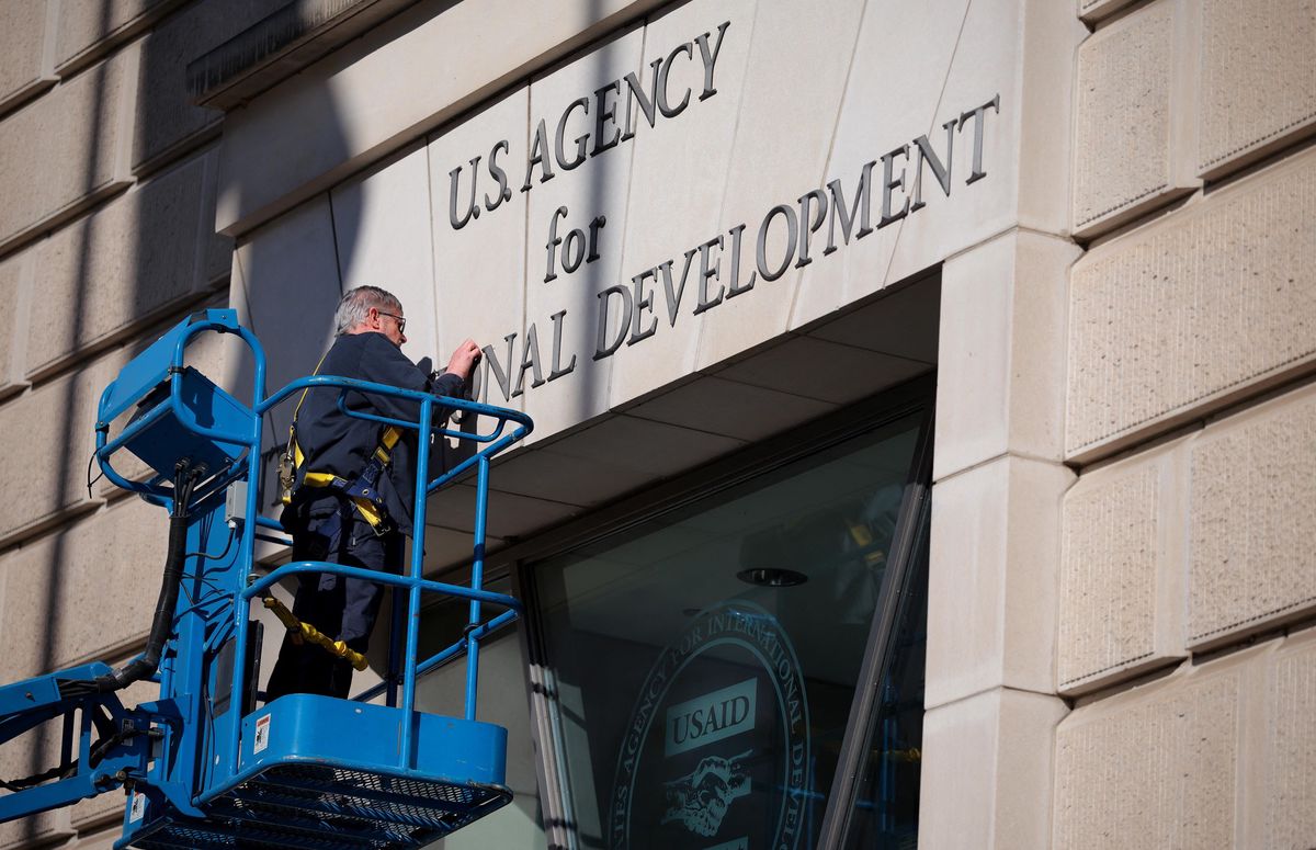 Un travailleur retire l’enseigne de l’USAID au siège de l'organisation à Washington, DC, le 7 février 2025.