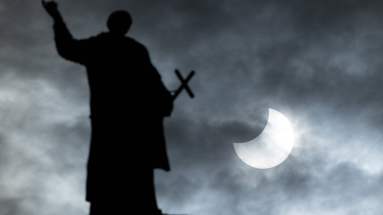 Partielle Sonnenfinsternis am 25. Oktober 2022 hinter der Statue der Hofkirche in Dresden.