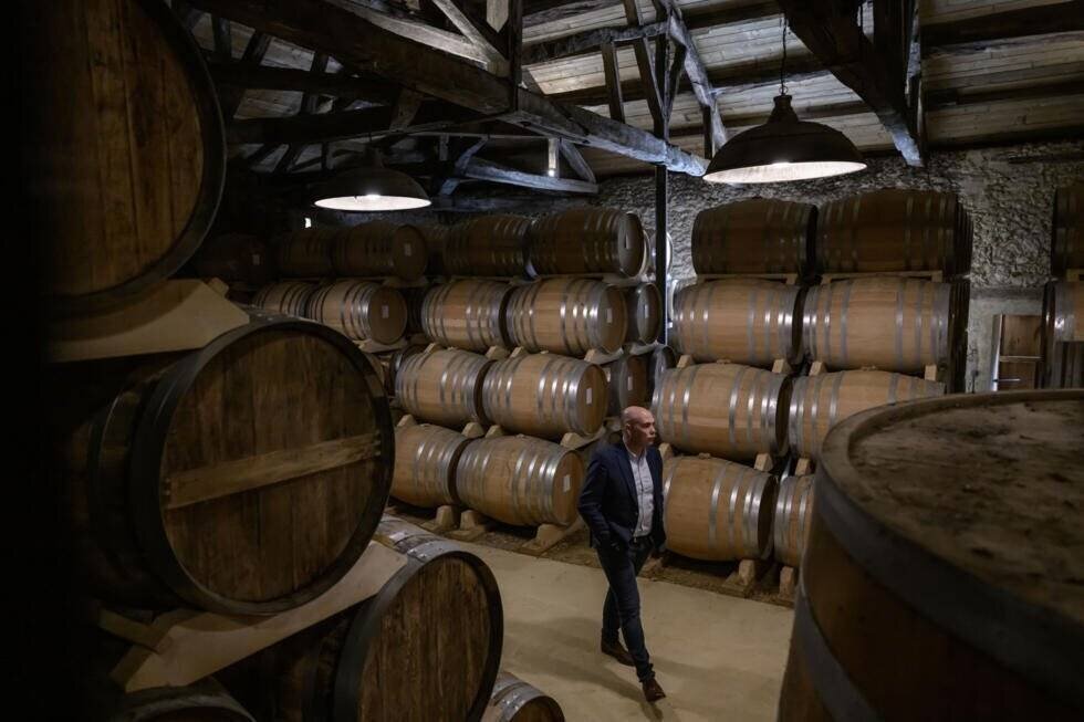 Jérôme Delord au milieu des fûts d'Armagnac à la distillerie Delord à Lannepax, le 20 mars 2025 dans le Gers