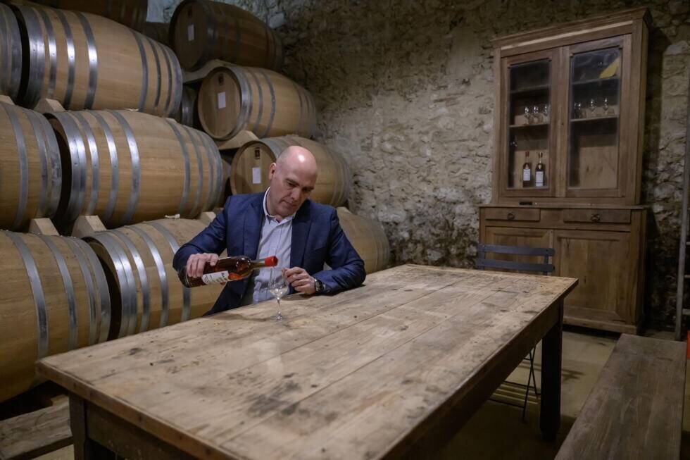 Jérôme Delord verse de l'armagnac dans un verre à la distillerie Delord à Lannepax, le 20 mars 2025 dans le Gers