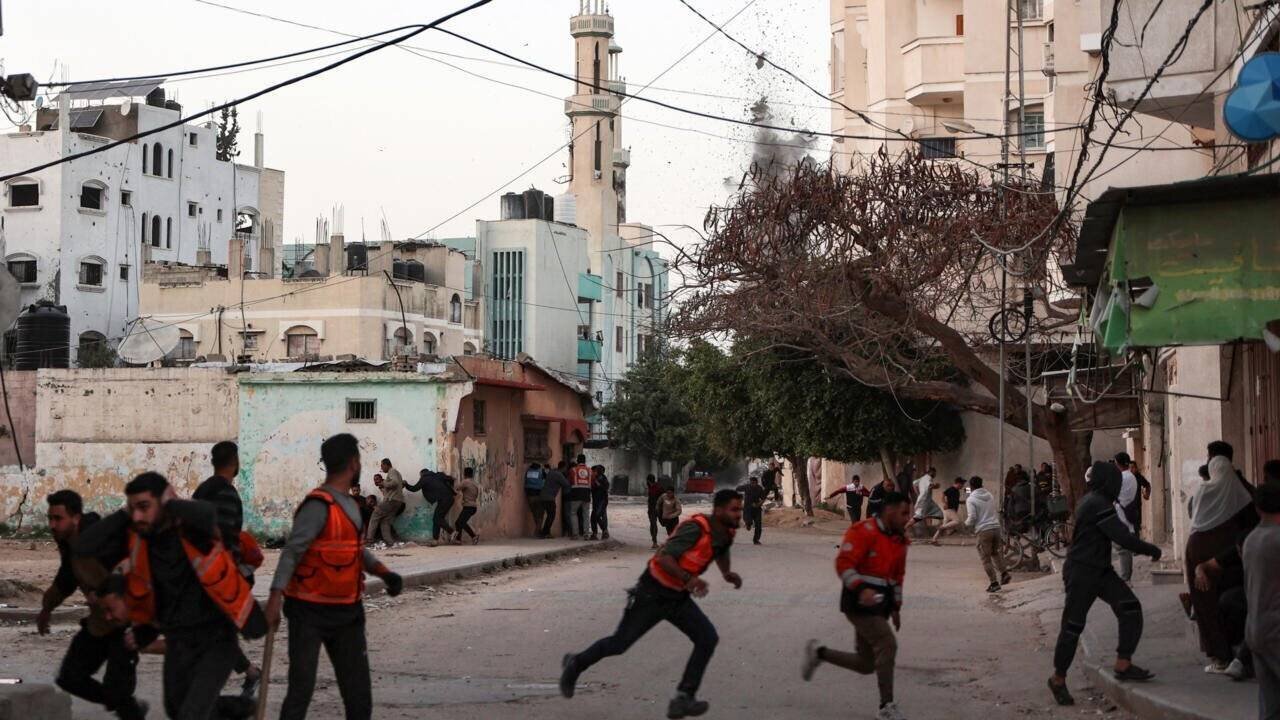 Des civils et des sauveteurs courent se mettre à l'abri lors d'une frappe israélienne sur une école, dans le quartier d'Al-Tuffah, dans la ville de Gaza, le 3 avril 2025.