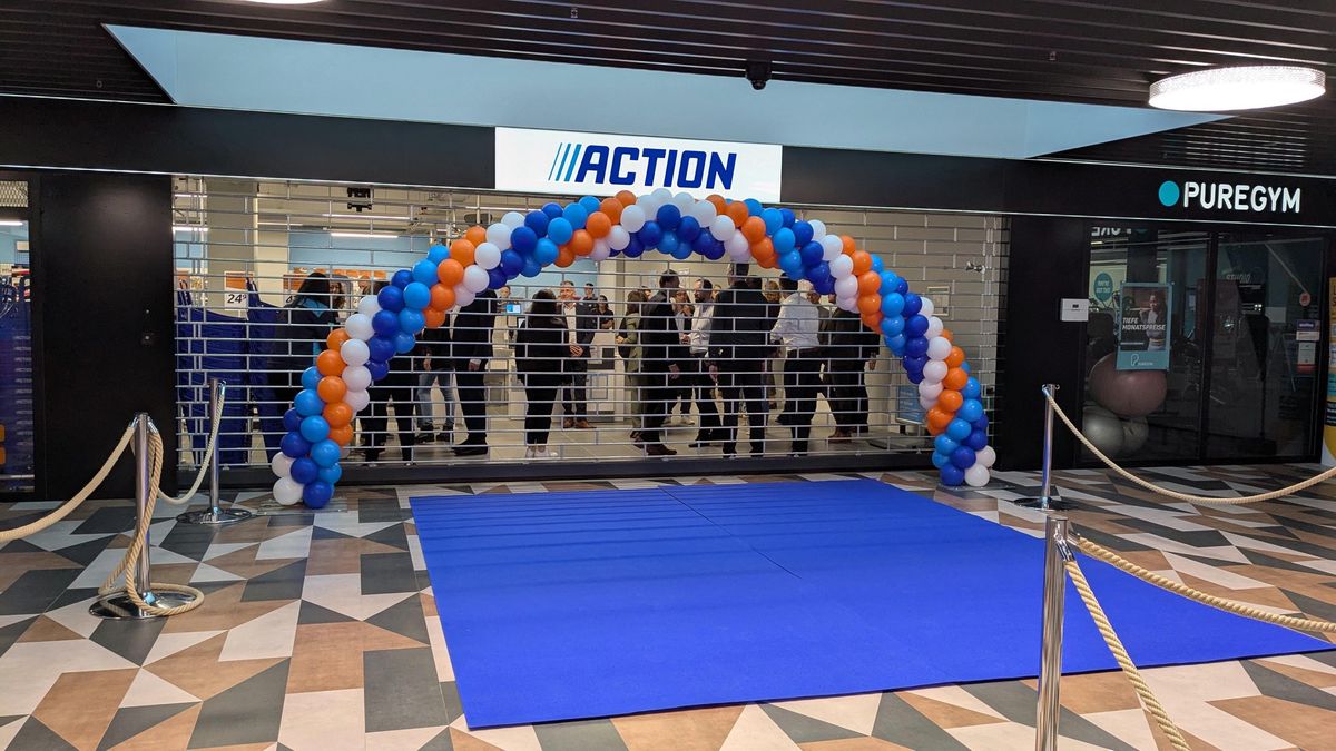 Entrée d'un magasin Action décoré avec des ballons colorés.