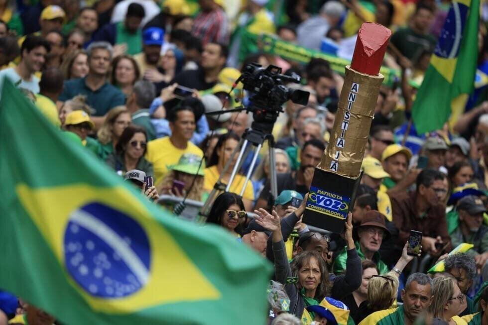 Des manifestants brandissent une pancarte en forme de bâton de rouge à lèvres géant, devenu un symbole du mouvement bolsonariste, le 6 avril 2025 à Sao Paulo