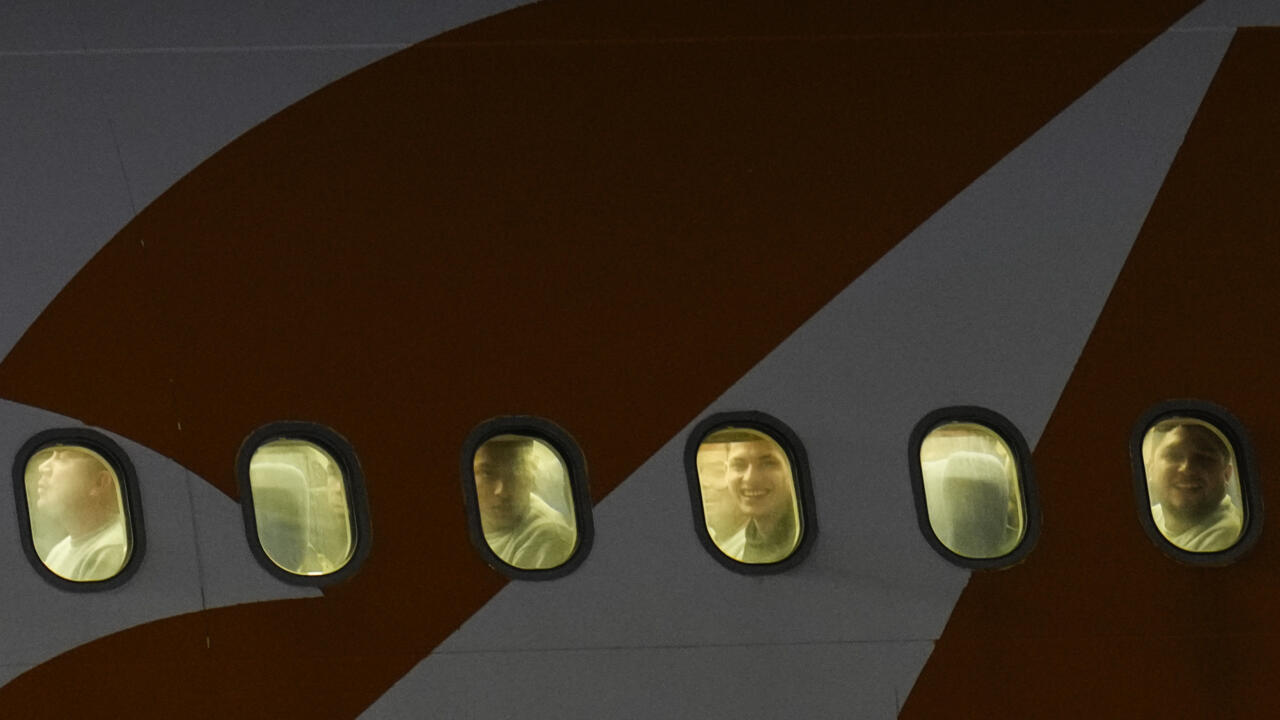 Des migrants vénézuéliens expulsés des États-Unis regardent par les hublots de leur avion à leur arrivée à l’aéroport international Simón Bolívar de Maiquetía, au Venezuela, le 24 mars 2025.