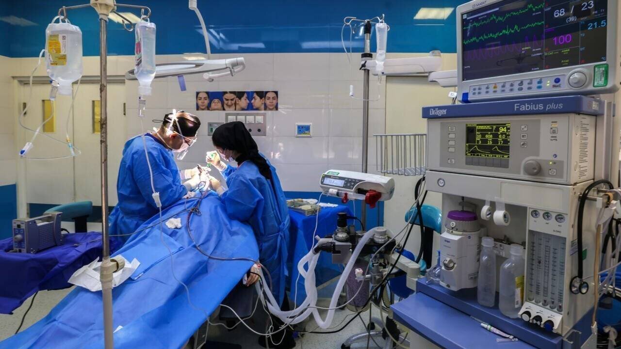 Hamidreza Hosnani et un assistant pratiquent une intervention chirurgicale dans la clinique privée du chirurgien à Téhéran.