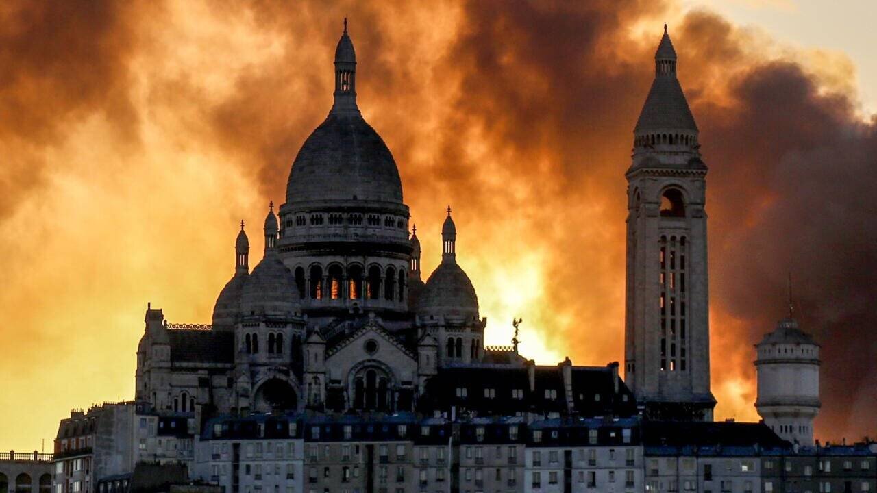 Un nuage de fumée derrière la basilique du Sacré-Cœur alors qu'un important incendie s'est déclaré dans le 17e arrondissement, dans le nord de Paris, le 7 avril 2025.