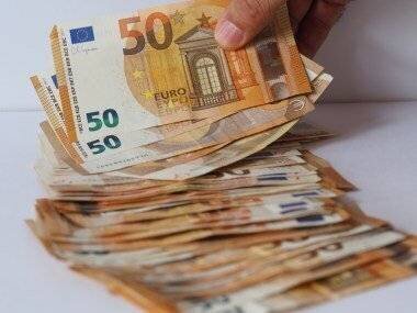 Main comptant une pile de billets de cinquante euros.