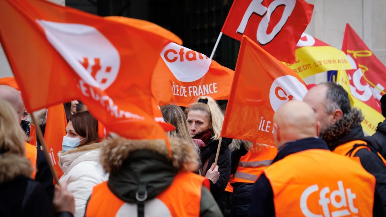 Des grévistes brandissent des drapeaux des syndicats CFDT, CGT et FO, le 17 janvier 2023 à Paris
