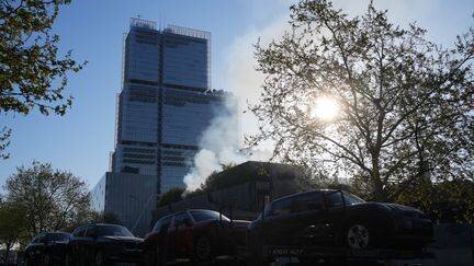 De la fumée s'échappe du site de l'incendie qui s'est déclaré la veille dans l'usine de recyclage du Syctom, au nord de Paris, le 8 avril 2025. (DIMITAR DILKOFF / AFP)