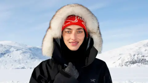 Camilla Hempleman-Adams dans un costume de neige, avec des montagnes enneigées en arrière-plan.