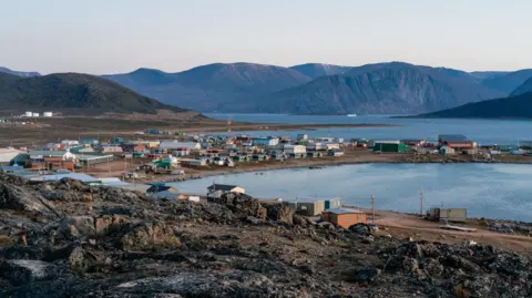 Vue d'un paysage arctique avec des maisons inuit.