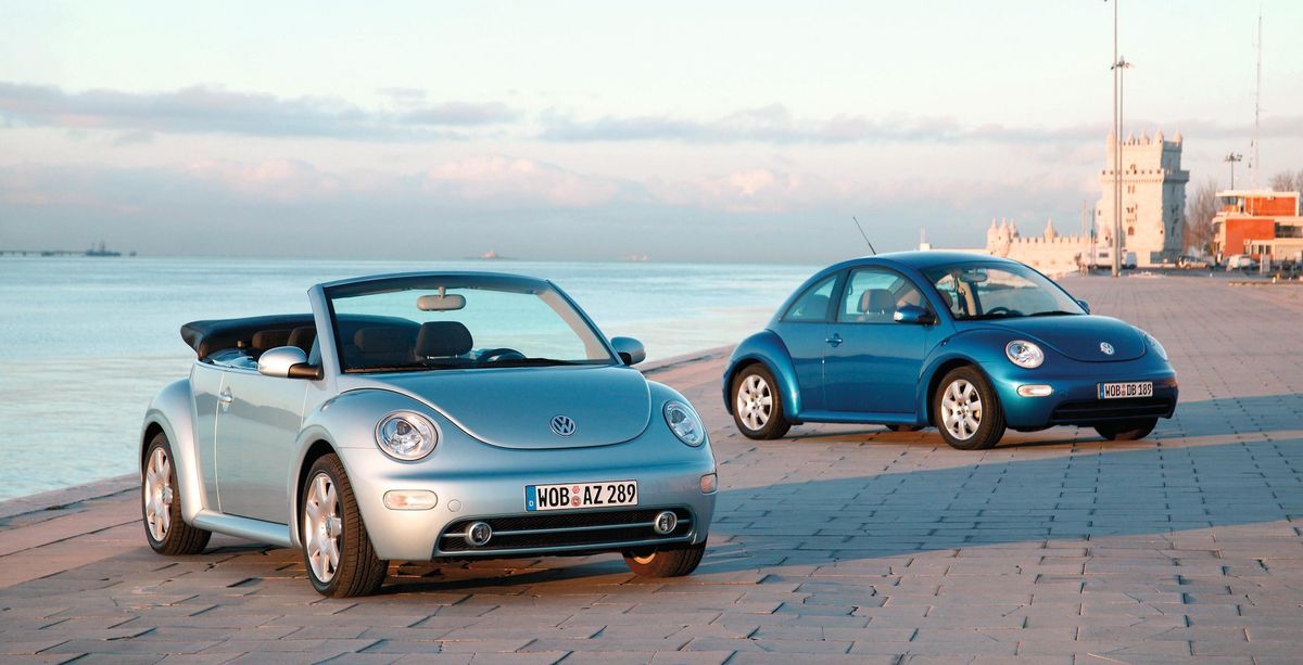 Deux VW Beetle Autos à une promenade côtière.