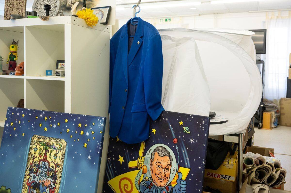 Le costume bleu d'Erich von Däniken dans une pièce décorée d'illustrations.