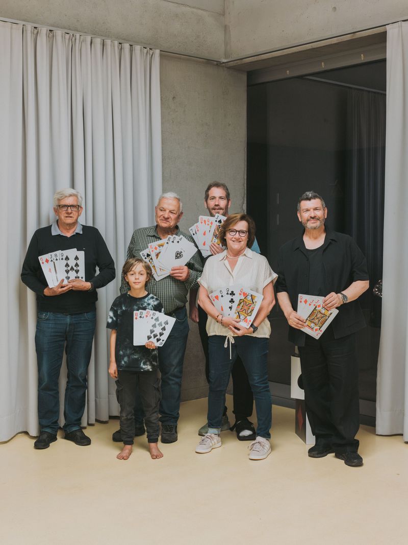 Groupe de joueurs posant avec des cartes géantes dans une salle moderne