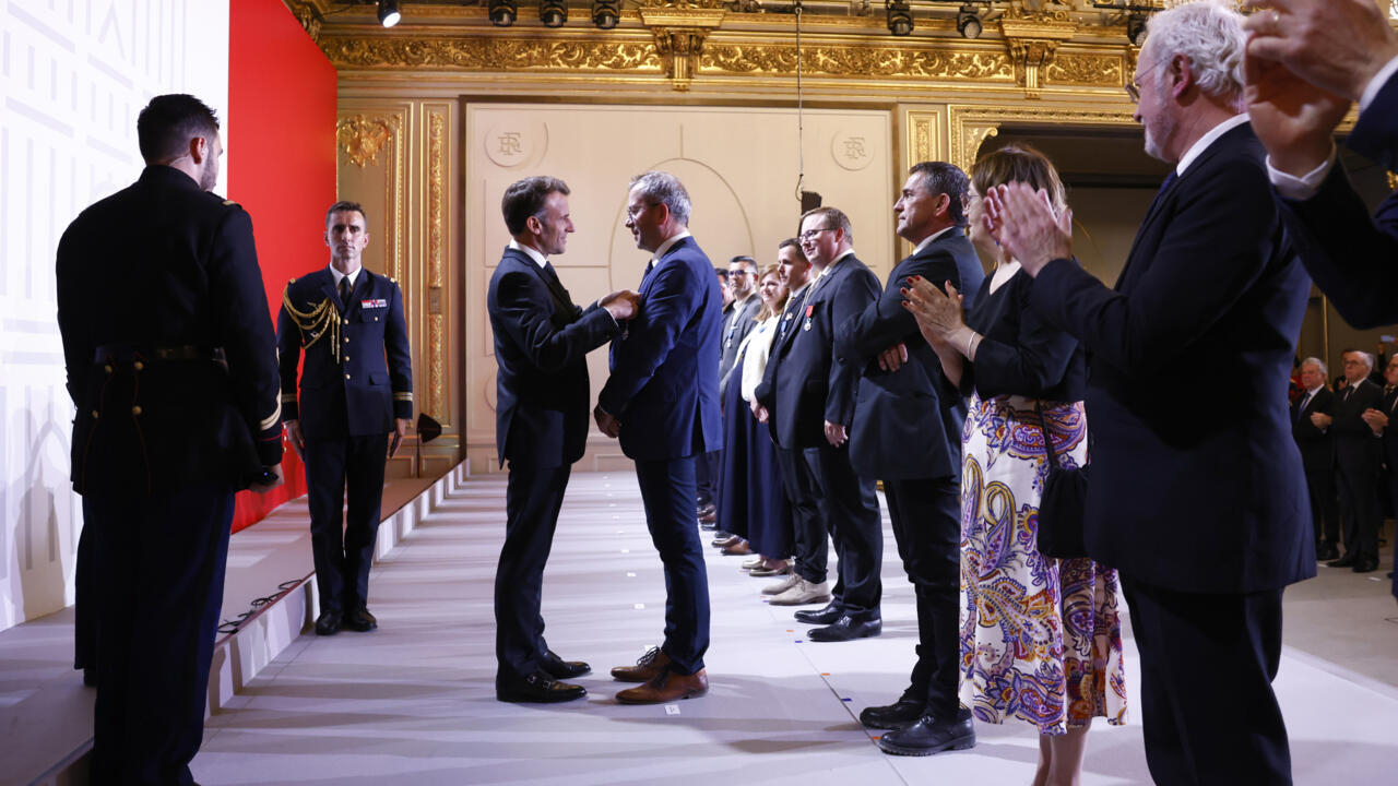Le président français Emmanuel Macron remettant plusieurs médailles