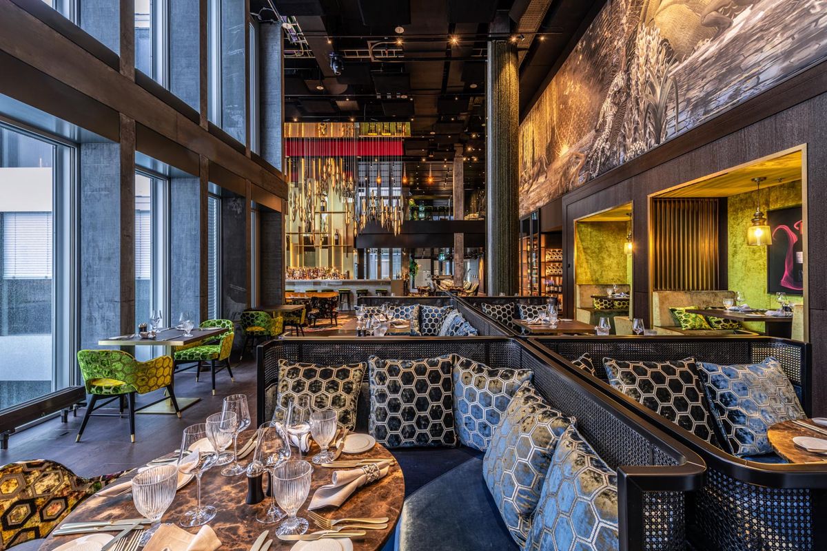 Intérieur moderne du restaurant avec sièges élégants, grandes fenêtres et décoration soignée